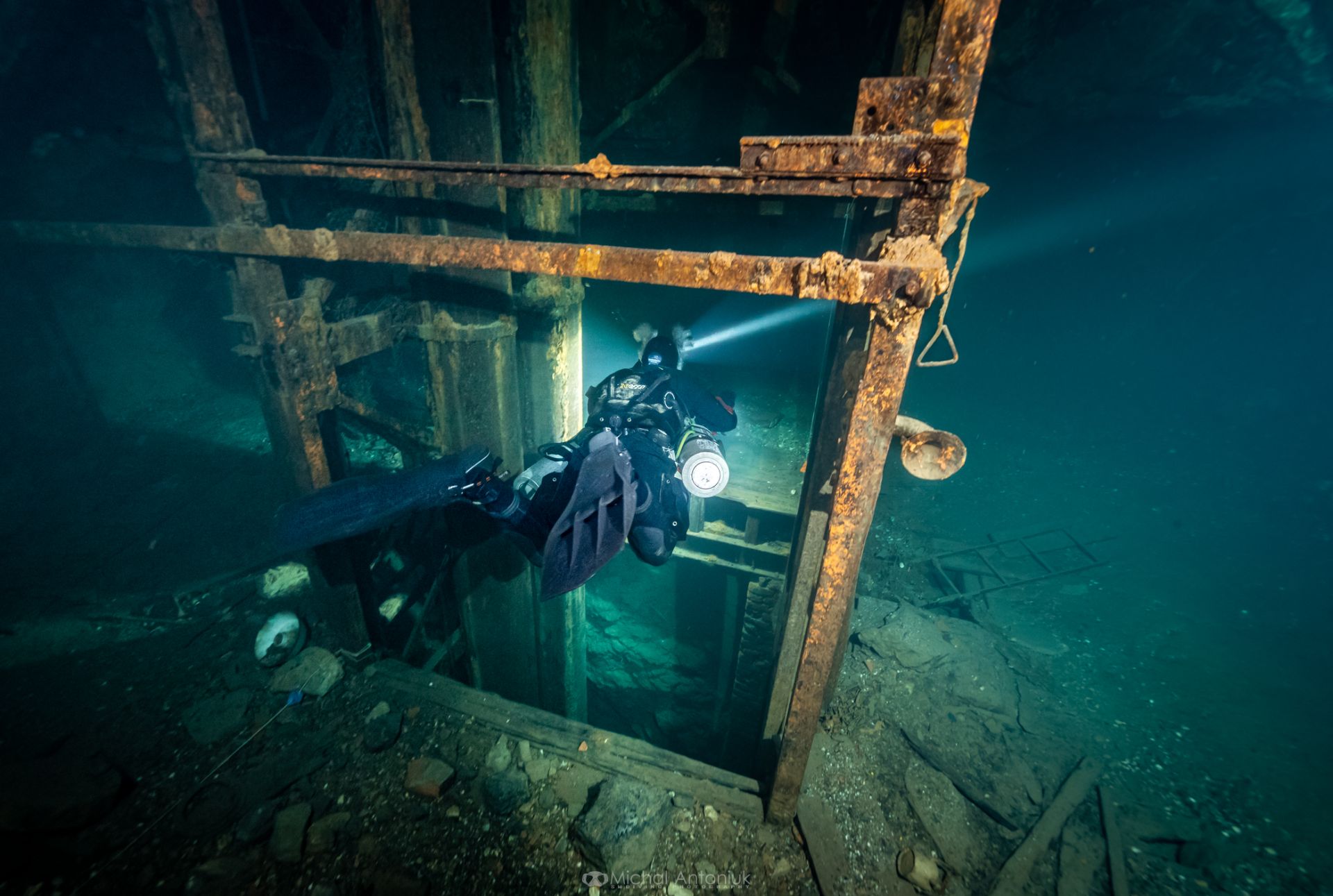 Cave diver in a rocky underwater passage. Photo: Michał Antoniuk